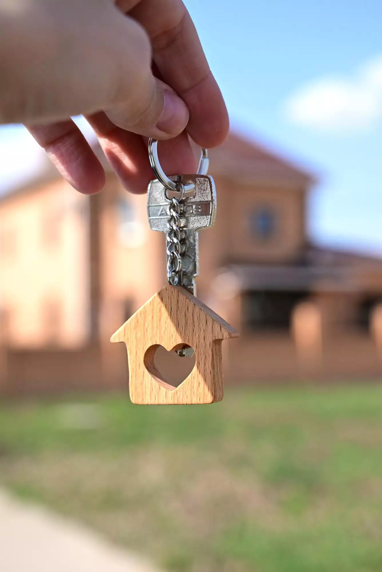 a key with a keychain in the form of a house with a heart on the background of the finished year of