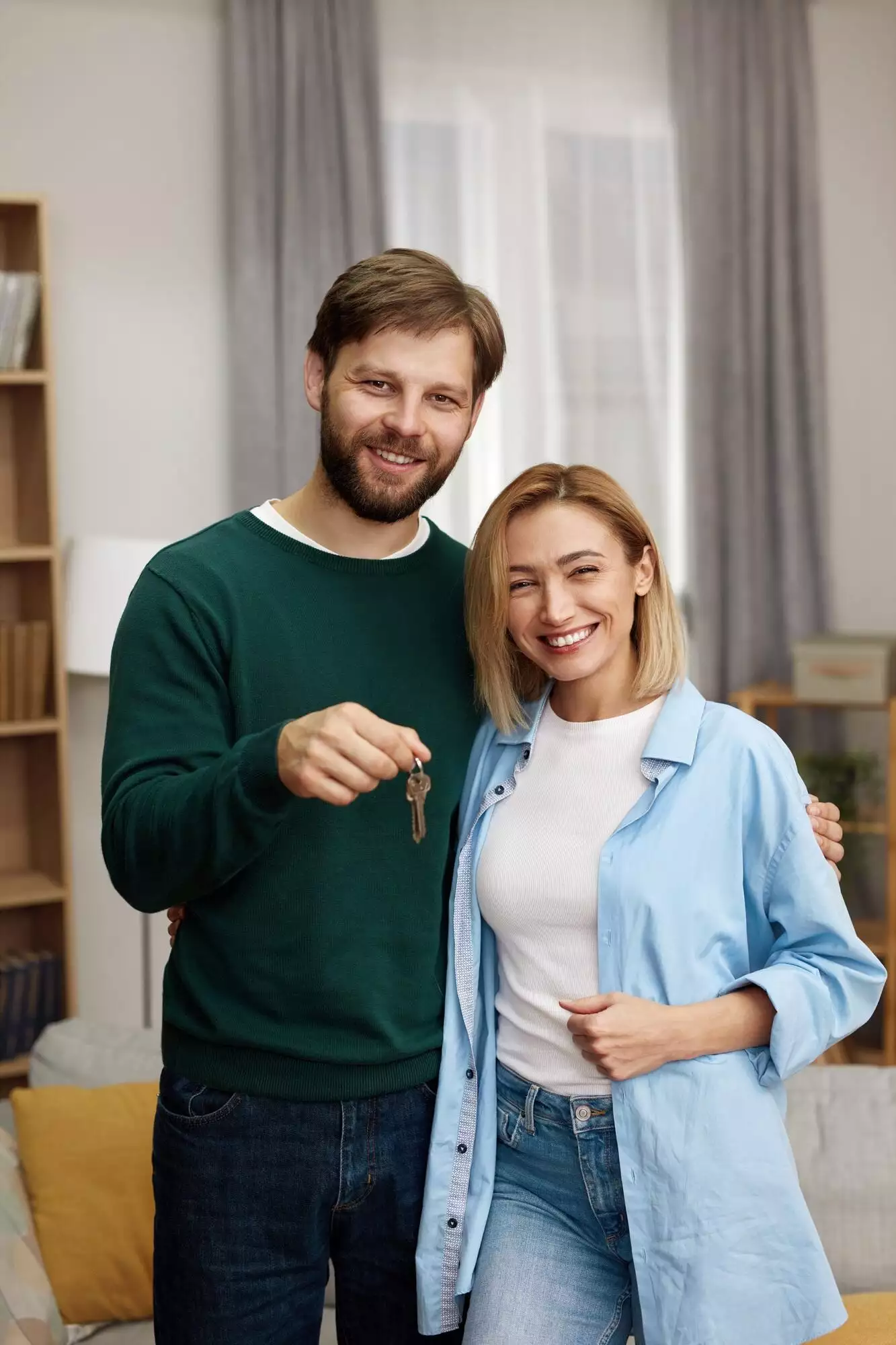 Happy Couple Holding Key. Happy Young Family Holding Key To New Home